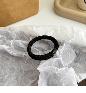 Detail eines schwarzen elastischen Haargummis mit dicker Flechtung und ovaler Perle