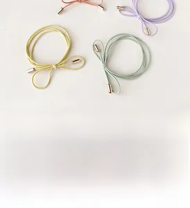 Close-up of pastel elastic hair ties with gold cylindrical metal decorative ends