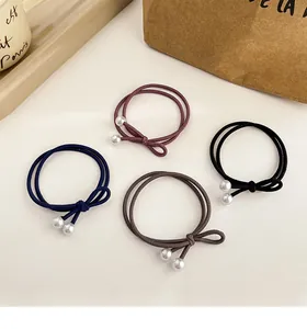 Détail de 4 chouchous à nœud et perles en couleurs bordeaux, bleu marine et gris