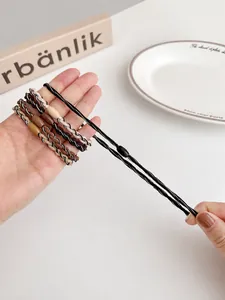 Close-up of high-elastic braided hair ties in earth tones showing stretch performance