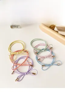 Detailed view of 5-piece candy-colored bow hair ties with elegant golden metal ends