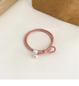 Détail de l'élastique à cheveux rose à double cordon avec perles d'imitation élégantes