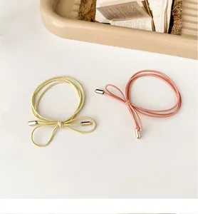 Detail of candy-colored bow hair ties with elastic cords and gold metal caps