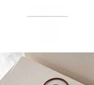 Detail view of a minimalist high-elasticity coffee-colored pearl hair ring on a textured base