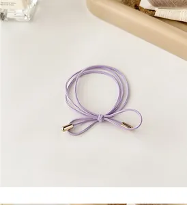 Close-up of a light purple high-elastic hair tie with elegant gold metal end caps