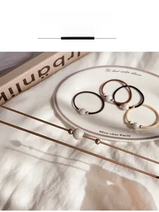Close-up of elastic pearl hair ties in neutral brown and beige tones with woven texture