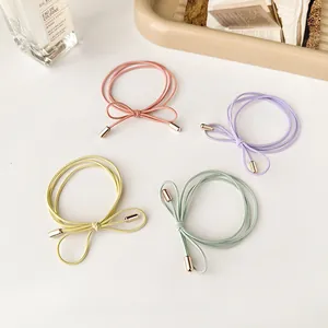 Set of four pastel bow hair ties with gold accents on white surface for styling