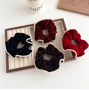 Set of four velvet scrunchies in red, black, and coffee colors with white polka dots