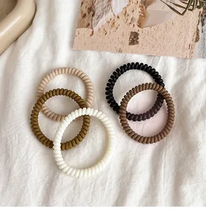 Macro detail of high-elasticity matte spiral hair ties in assorted earth-tone colors