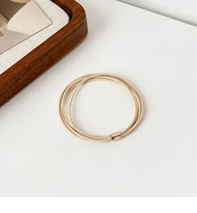 Detail of high-elastic multi-strand champagne gold hair tie with sleek metal buckle
