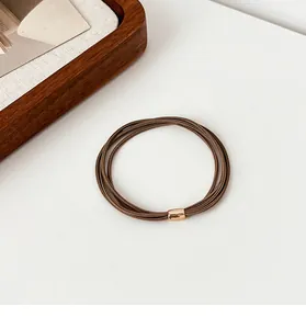 Close-up of high-elastic coffee brown hair tie set with decorative gold metal oval buckle