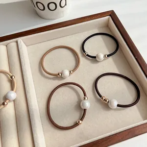 Set of 4 high-elastic pearl hair ties in neutral coffee tones on a jewelry tray