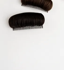 Close-up of two natural black hair volume pads with integrated combs for invisible root lift