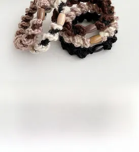 Détail de chouchous spirales tressés avec perles ovales aux tons de terre