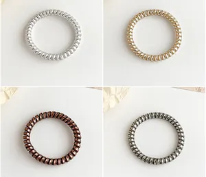 Macro view of metallic spiral hair ties in silver, gold, bronze and grey colors
