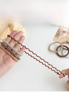 Close-up of flexible spiral hair ties in metallic colors showing high elasticity