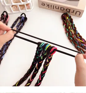 Gros plan d'une main étirant un élastique à cheveux tressé coloré haute élasticité