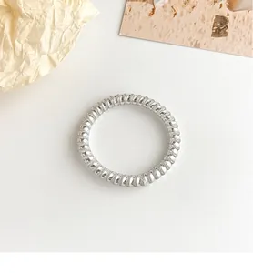 Macro shot of silver spiral ring showing detailed twisted texture and metallic luster