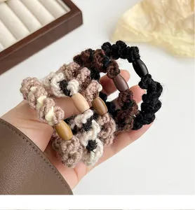 Détail de chouchous en tricot avec perles brillantes en noir, marron et crème