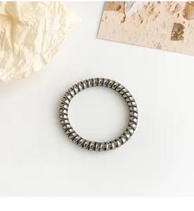 Detail view of silver spiral telephone wire hair tie with elastic metallic finish