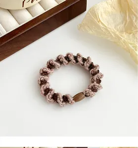Gros plan d'un élastique spirale tricoté rose et marron avec une boucle en plastique