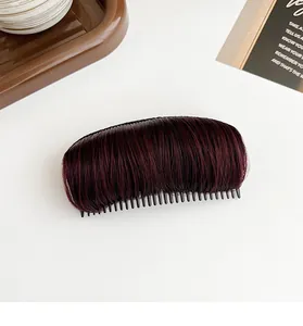 Macro view of burgundy hair padding clip with black plastic comb for volume