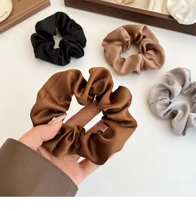 Détail de chouchous en satin aux tons terreux avec texture soyeuse et éclat délicat