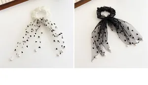 Dettaglio di elastici in pizzo con pois a cuore ed eleganti ciondoli di perle