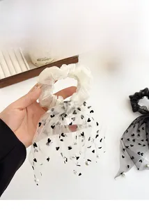 Dettaglio di scrunchies in tulle con cuori e ciondoli a perla molto eleganti