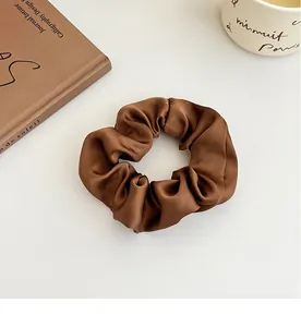 Gros plan d'un chouchou en satin marron foncé avec un aspect soyeux et des plis doux