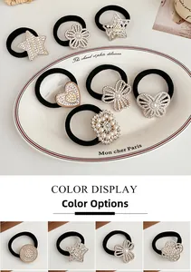 Detail of elastic hair ties with rhinestone butterfly and pearl star charms in white tray