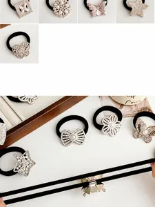 Detail display of black elastic hair ties with rhinestone butterflies and star charms