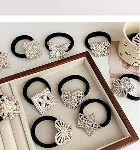 Détails de chouchous élastiques avec papillons en strass et perles sur un plateau