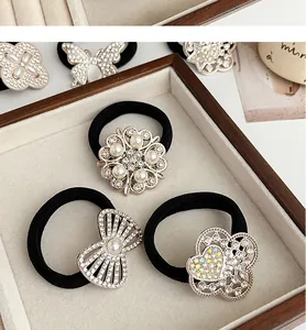 Détail d'élastiques à cheveux noirs avec charms papillon en perles et strass