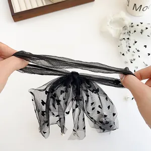 Elastico per capelli in mesh nero con cuori e perline bianche mostrato in alta elasticità