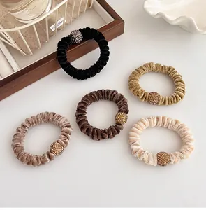 Velvet hair scrunchies with rhinestone balls in assorted neutral colors and soft texture