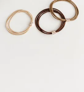 Detailed view of elastic hair ties in beige and coffee tones with rhinestone metal clips