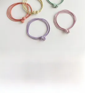 Detail of four-strand elastic hair ties with woven knots in various macaron colors
