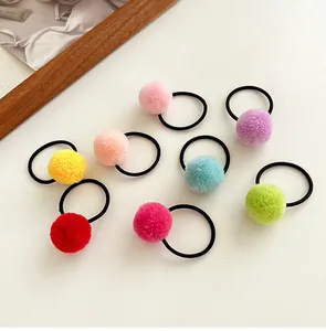 Set of 8 colorful plush ball hair ties for girls on a minimalist white background