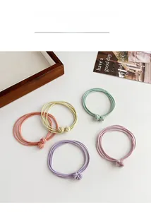 Detailed view of high elasticity macaron hair ties with delicate knot design on a tray
