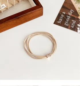 Close-up of beige elastic hair tie with sparkling rhinestone bow knot metal buckle detail
