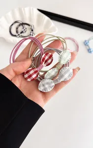 Detail of checkered bow elastic hair ties in red, green, and gray colors for girls
