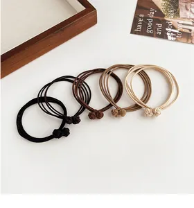 Detail of four-color elastic hair ties with triple-strand knot design in earth tones