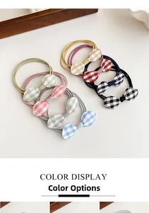 Detail showing various colors of plaid bow hair ties on a white background