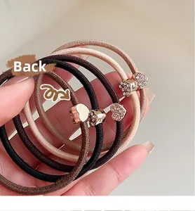 Dettaglio di elastici per capelli con ciondolo a cuore in strass, vista frontale e posteriore