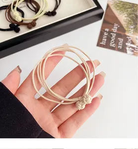 Macro detail of elastic hair tie set with woven knot decoration in cream and brown