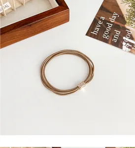 Detail of coffee brown elastic hair tie set with rose gold rhinestone metal buckle