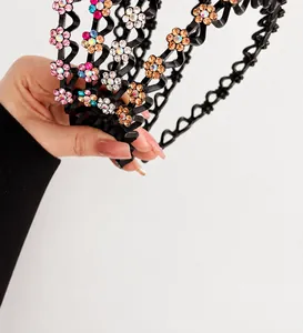 Detail van de golvende antislip haarband met kleurrijke strass-bloemen op zwart plastic