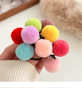 Close-up of colorful pom-pom hair ties for children made with soft plush material