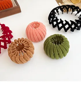 Flat lay of colorful velvet flocked bird nest hair clips on a clean white desk